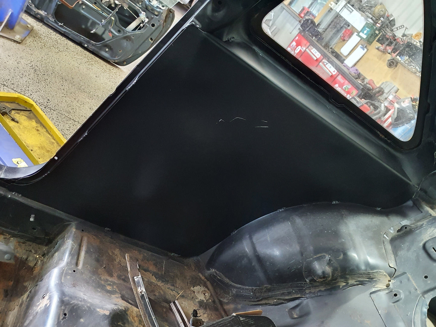 Car interior dashboard with a black mat and visible tools in a workshop setting