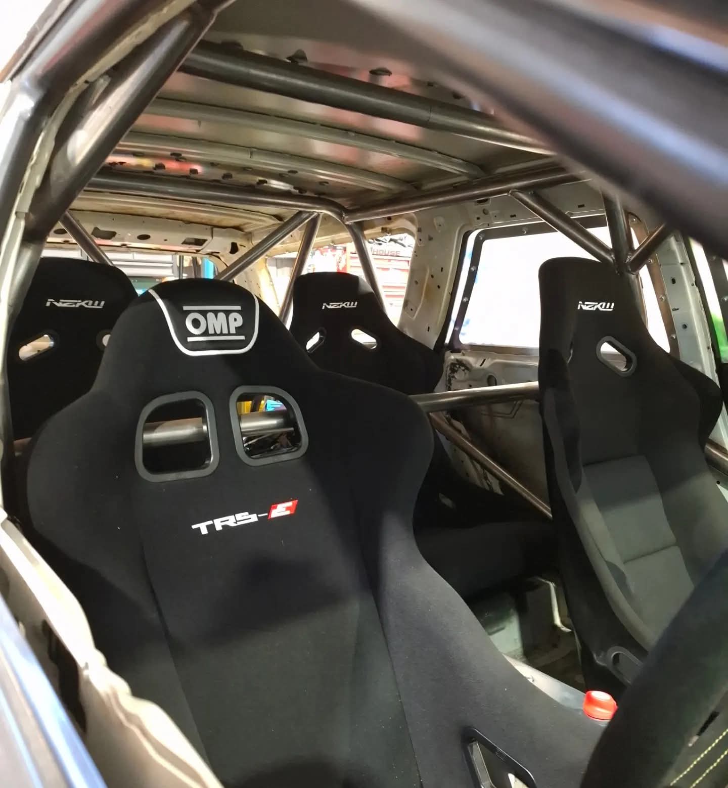 4 racing seats in a car with steel rollcage
